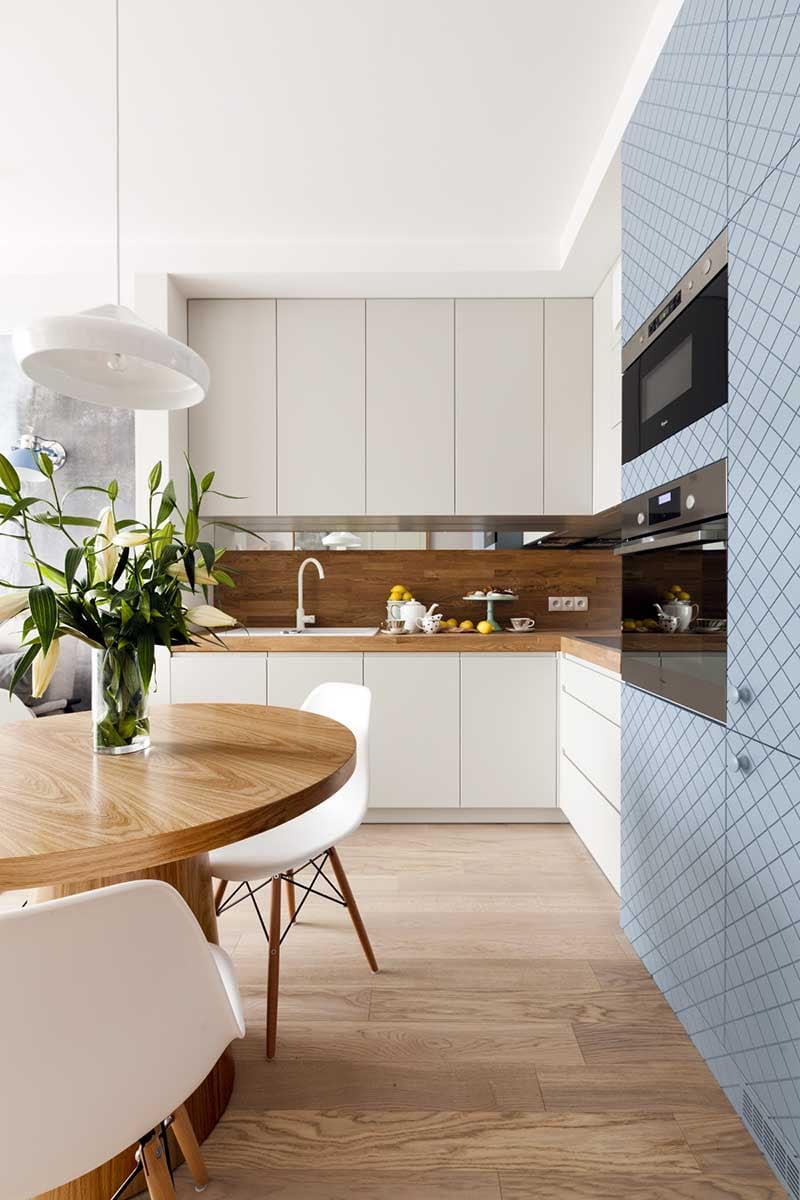 Drewniana ściana nad blatem doskonale koresponduje z okrągłym stołem