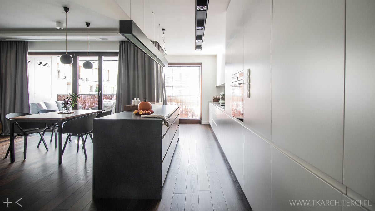 Biała kuchnia otwarta na salon i jadalnię | proj. TK Architekci